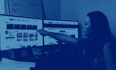 A woman points to learning modules on a screen