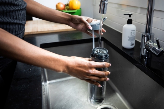filling reusable water bottle